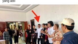 Tangkapan layar facebook yang menampilkan foto Ketua KIP Lhokseumawe berpose simbol 