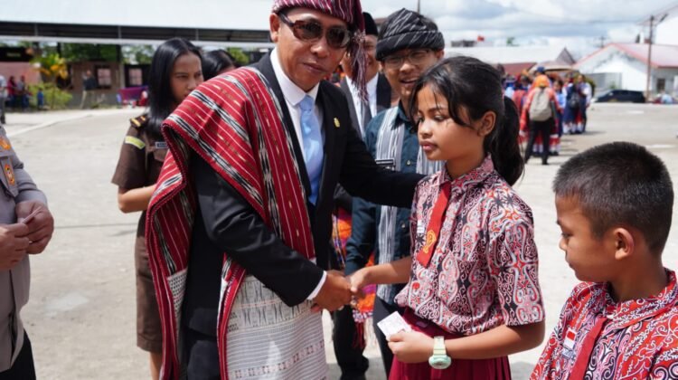 Bupati Taput Jonius TP Hutabarat didampingi Kadis Dukcapil Romusa Simanungkalit serahkan KIA kepada Anak pada momen Hari Anak Nasional.(Ist)