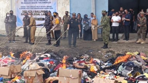 Bea Cukai Teluk Nibung dan Kejari Tanjung Balai memusnahkan 255 karung pakaian bekas selundupan serta lebih dari 200.000 batang rokok ilegal, Selasa (27/10/2026). 