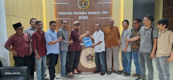 Penyerahan berkas pendaftaran berupa formulir dalam map berwarna biru, diserahkan Sekretaris SC kepada Hendro Saky di Lobby Kantor PWI Aceh. | Foto KBA.ONE, Dian Emsaci.